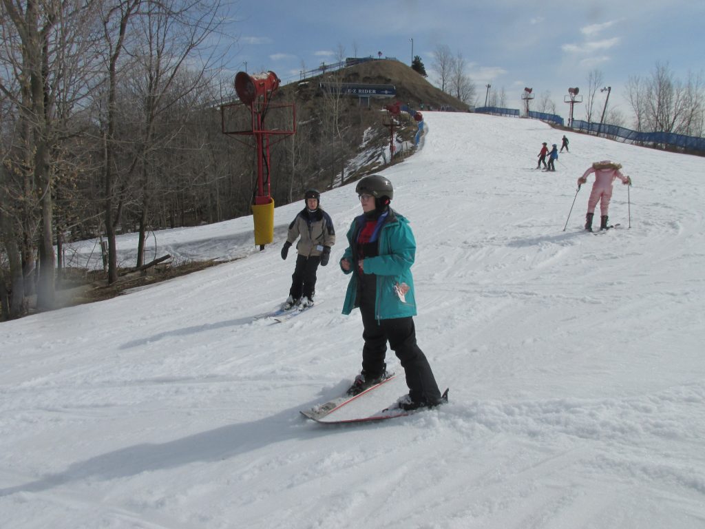 student stand-up skiing in a wedge without poles